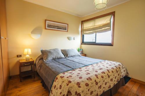 a bedroom with a bed and a window at Cabañas Piedra Grande in Pichilemu