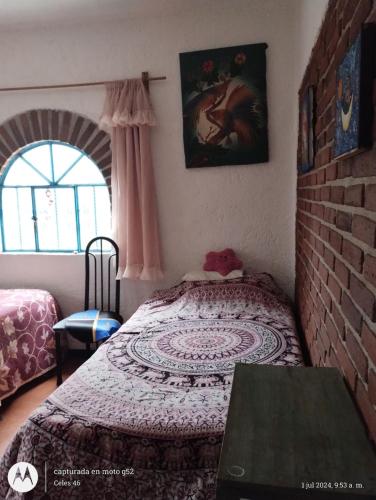 a bedroom with a bed and a brick wall at Eco Rooms Pablo's in Curva La Pera