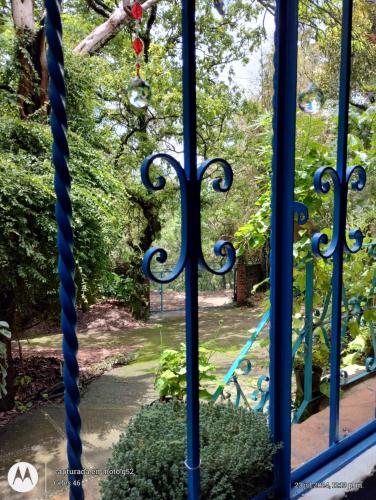 a blue gate with a garden behind it at Eco Rooms Pablo's in Curva La Pera