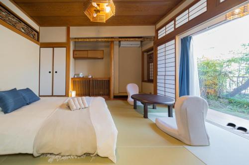 a bedroom with a bed and a large window at RELAX Condo Namba Daikokucho in Osaka