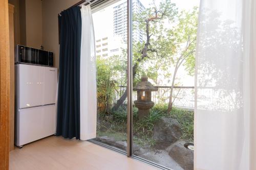 a kitchen with a large sliding glass door with a window at RELAX Condo Namba Daikokucho in Osaka