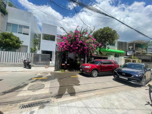 Deux voitures garées sur le côté d'une rue dans l'établissement Kinh Do Homestay, à Hương Trà