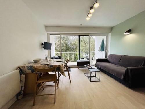 un salon avec un canapé et une table dans l'établissement Charmant T2 près de la plage avec balcon, parking et commodités à pied - 4 pers, Le Pouliguen - FR-1-245-195, au Pouliguen