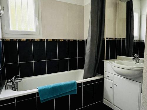 une salle de bain avec une baignoire et un lavabo dans l'établissement Appartement T2 avec piscine, proche thermes, terrasse, parking, petit animal OK, Cambo-les-Bains - FR-1-495-142, à Cambo-les-Bains