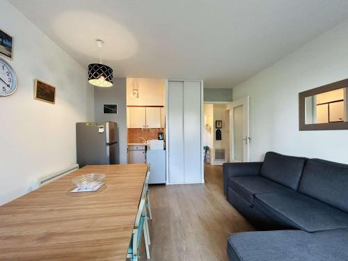 un salon avec un canapé et une table dans l'établissement Appartement 2 pièces cabine avec jardin, proche centre et marché - 4 couchages, Le Pouliguen - FR-1-245-208, au Pouliguen