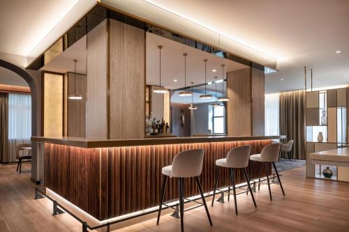 a lobby with a bar with stools at AC Hotel by Marriott Clodio Roma in Rome