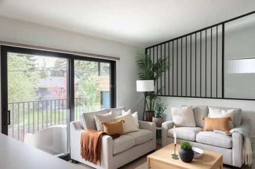 a living room with two couches and a balcony at Casa Bramble Luxury 2Bed Suite near UofA Hospital in Edmonton