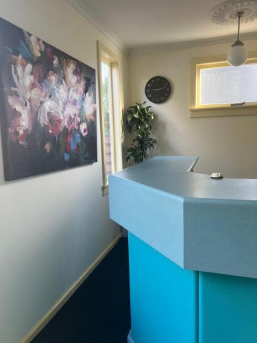a kitchen with a blue counter and a painting on the wall at Penny's B&B Accommodation in Palmerston North