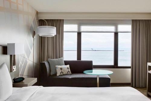 a bedroom with a bed and a couch and a table at San Francisco Airport Marriott Waterfront in Burlingame
