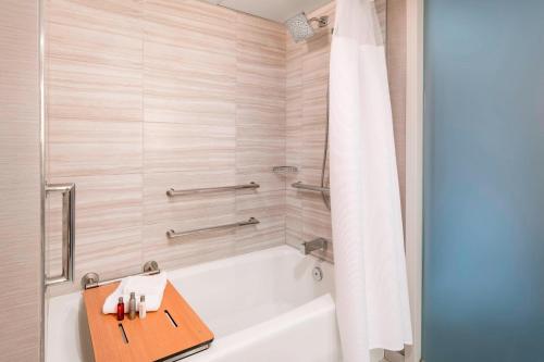 a bathroom with a bath tub with a wooden tray at San Francisco Airport Marriott Waterfront in Burlingame