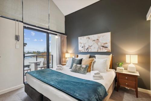 a bedroom with a large bed and a balcony at Luxurious City Apartment in Perth