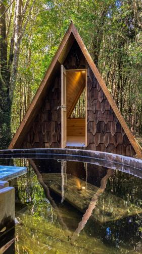 a small house in the middle of a pond at Parque Repuleufu Chiloé in Ancud