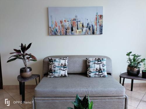 a couch in a living room with a painting on the wall at Warmisitay Mini departamento in Lima