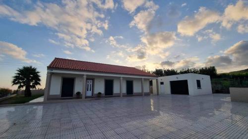 a small white building with a cloudy sky at Azores Treasure in Angra do Heroísmo