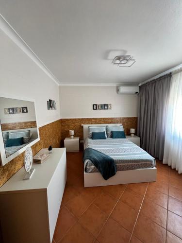 a bedroom with a king sized bed and a desk at Azores Treasure in Angra do Heroísmo