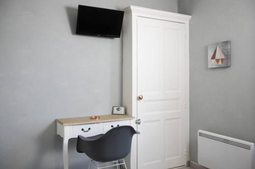 Cette chambre comprend un bureau et une chaise à côté d'une porte. dans l'établissement Studio cosy à Clermont-Ferrand 25 m² proche transport, à Clermont-Ferrand