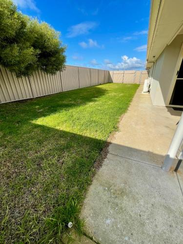 a yard of grass next to a fence at Sand & Salt in Kingscote