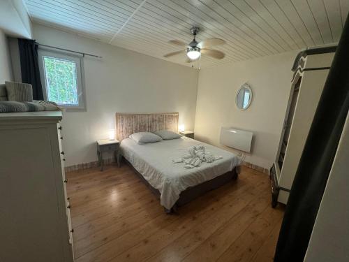 una camera da letto con un letto e un ventilatore a soffitto di A casa nostra a Biguglia