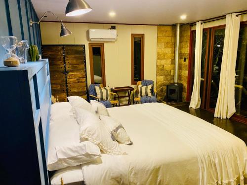 a bedroom with a large bed with white sheets and pillows at Nidos de Apalta in Santa Cruz
