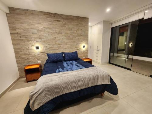 a bedroom with a large bed and a brick wall at Casa de campo de estreno en Cieneguilla, Lima-Perú in Cieneguilla