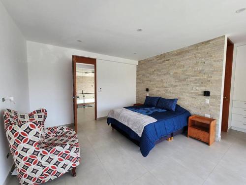 a bedroom with a bed and a chair at Casa de campo de estreno en Cieneguilla, Lima-Perú in Cieneguilla