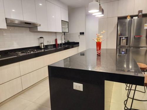 a kitchen with a counter with a vase of flowers on it at Casa de campo de estreno en Cieneguilla, Lima-Perú in Cieneguilla