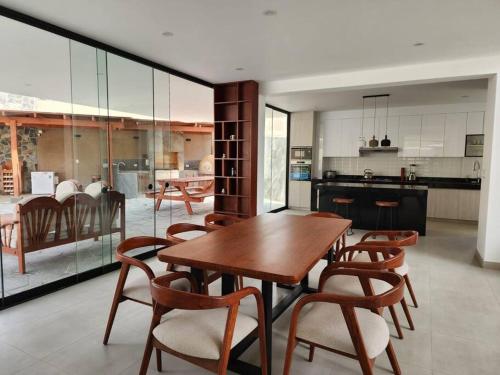 a kitchen and dining room with a wooden table and chairs at Casa de campo de estreno en Cieneguilla, Lima-Perú in Cieneguilla
