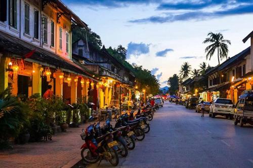 a group of motorcycles parked on a street at night at Nirasim Villa in Luang Prabang