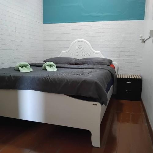 a white bed with two green towels on it at Sleep at home hostel in Bangkok