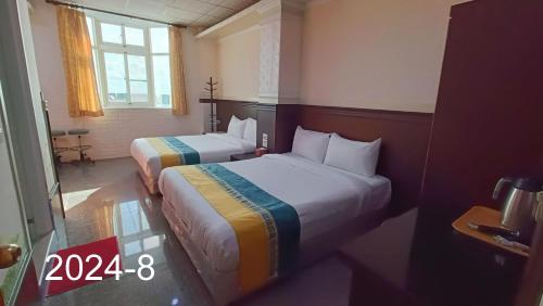 a hotel room with two beds and a window at 安德飯店 in Green Island