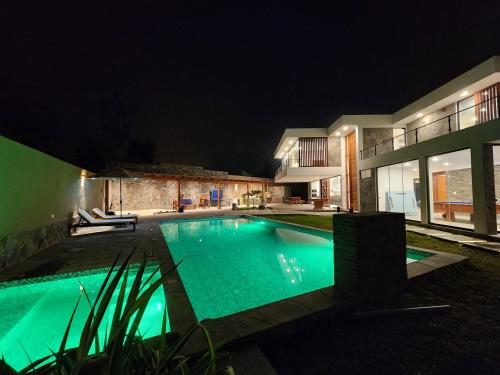 a swimming pool in front of a house at night at Casa de campo de estreno en Cieneguilla, Lima-Perú in Cieneguilla
