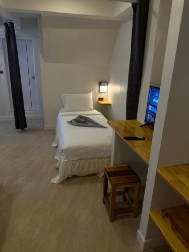 a bedroom with a bed and a desk with a computer at Aussieland Bungalows in Lamai