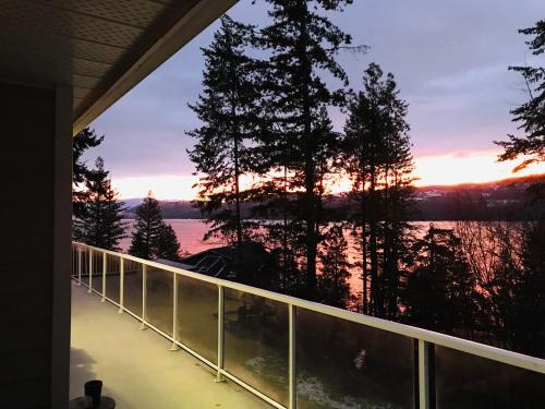 a view from the balcony of a house with a sunset at Blarney Place Retreat in Vernon