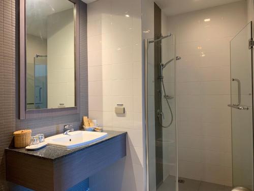 a bathroom with a sink and a glass shower at Classic Kameo Hotel & Serviced Apartment, Rayong in Rayong