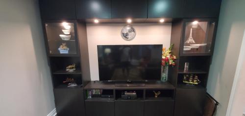a living room with a flat screen tv and shelves at Beautiful House in Mississauga in Mississauga