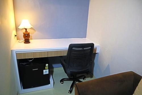 a desk with a chair next to a computer at The Al's By ZIRI in Surabaya
