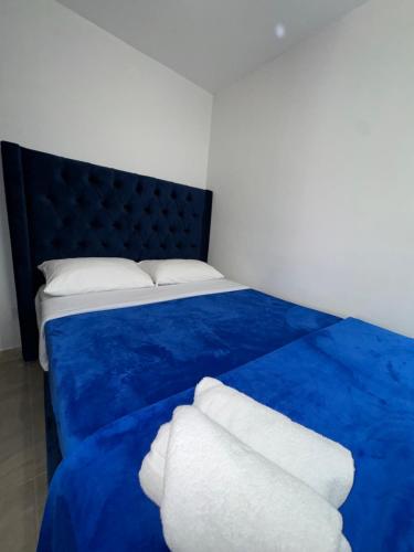 a blue bed with two white towels on it at Casa Villa Paz Salento in Salento
