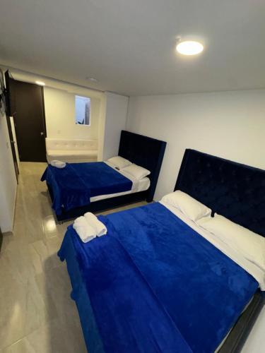 two beds in a room with blue sheets at Casa Villa Paz Salento in Salento