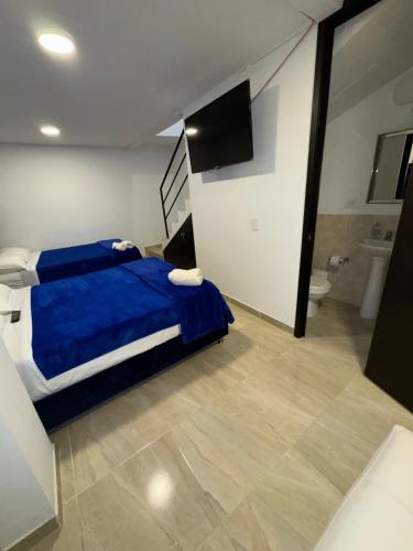 a bedroom with a blue bed and a bathroom at Casa Villa Paz Salento in Salento