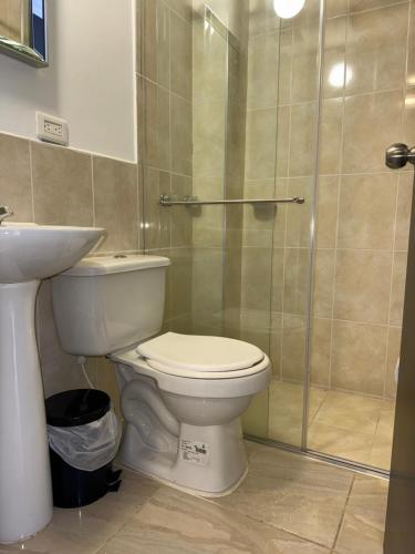 a bathroom with a toilet and a glass shower at Casa Villa Paz Salento in Salento