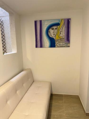 a white couch in a room with a painting on the wall at Casa Villa Paz Salento in Salento