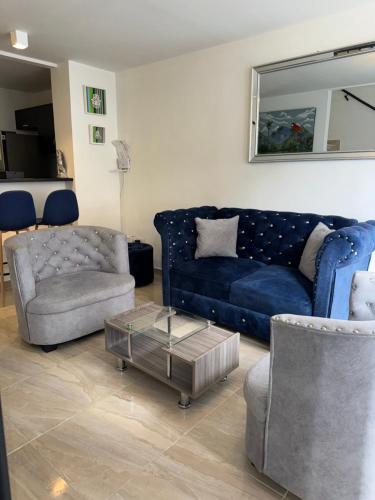 a living room with a blue couch and a chair at Casa Villa Paz Salento in Salento