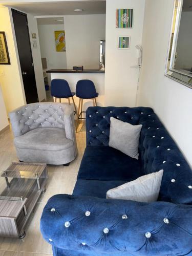 a living room with a blue couch and a chair at Casa Villa Paz Salento in Salento