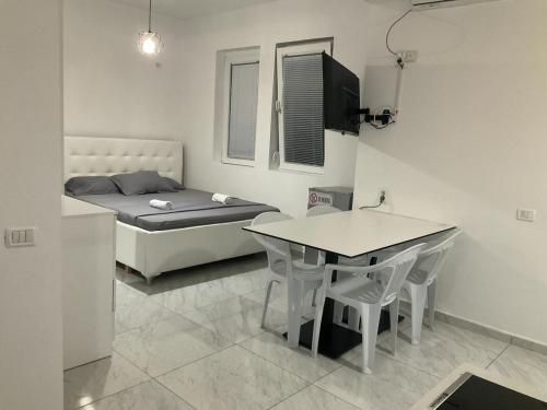 a small room with a bed and a table and chairs at Golem Apartment in Golem