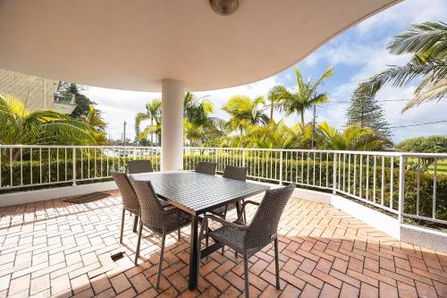 a patio with a table and chairs on a balcony at Mirage Unit 101 in Tuncurry