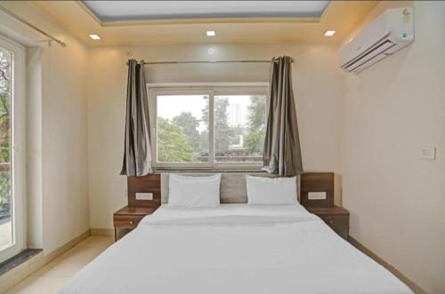 a bedroom with a large bed and a window at Expo View INN in Greater Noida