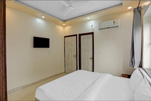 a bedroom with a white bed and a tv at Expo View INN in Greater Noida