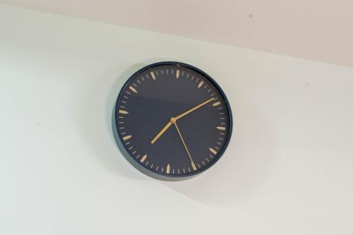 a black clock hanging on a white wall at Sree Theja Residency in Anantapur