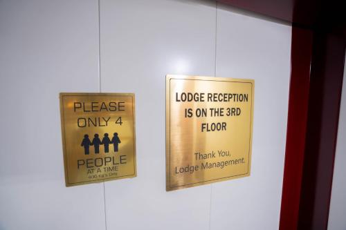a couple of signs on the door of a bathroom at Sree Theja Residency in Anantapur