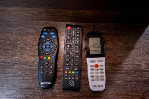three remote controls sitting next to each other on a table at Sree Theja Residency in Anantapur